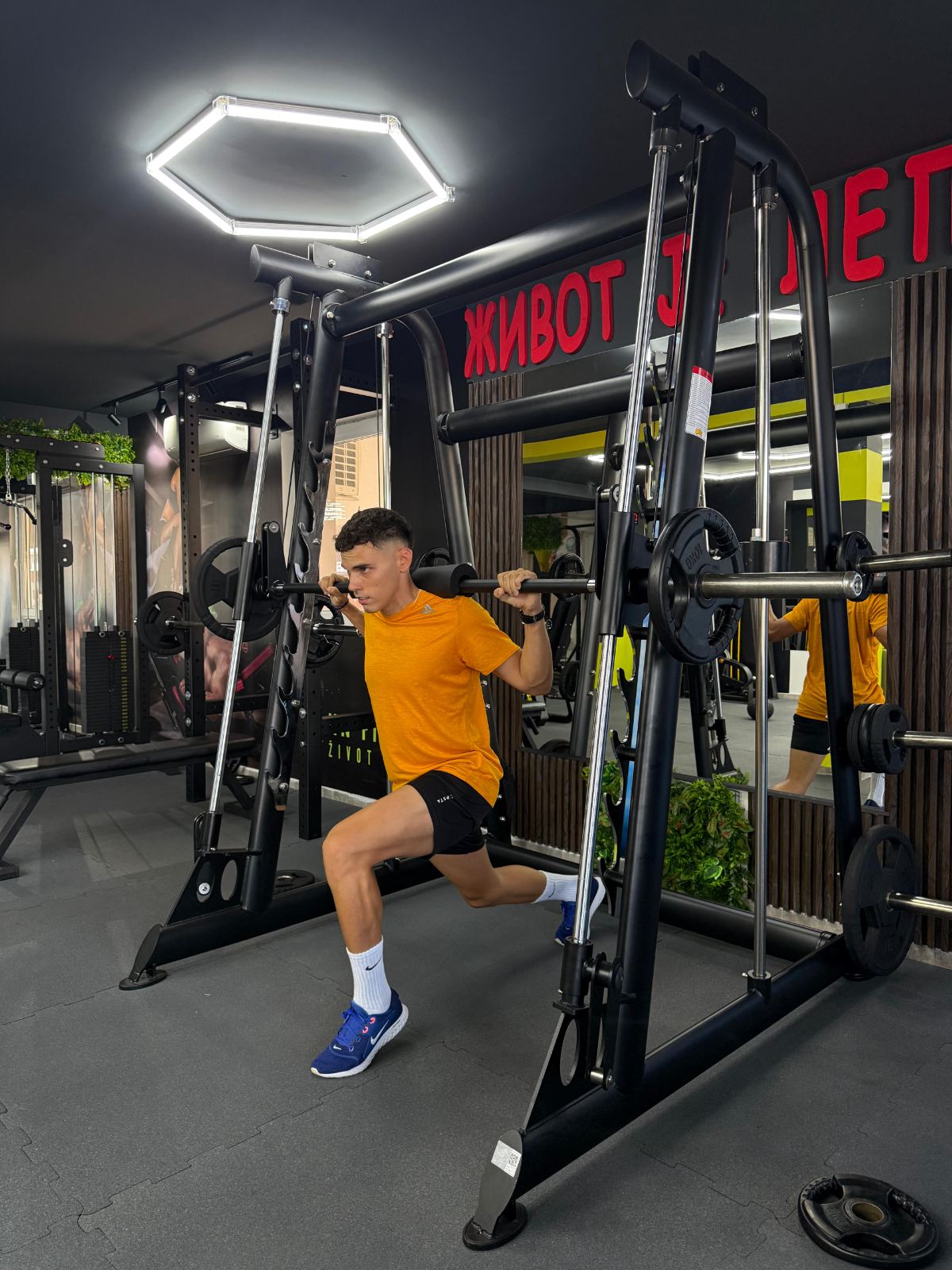 Sportista radi iskorak sa šipkom na Smit mašini