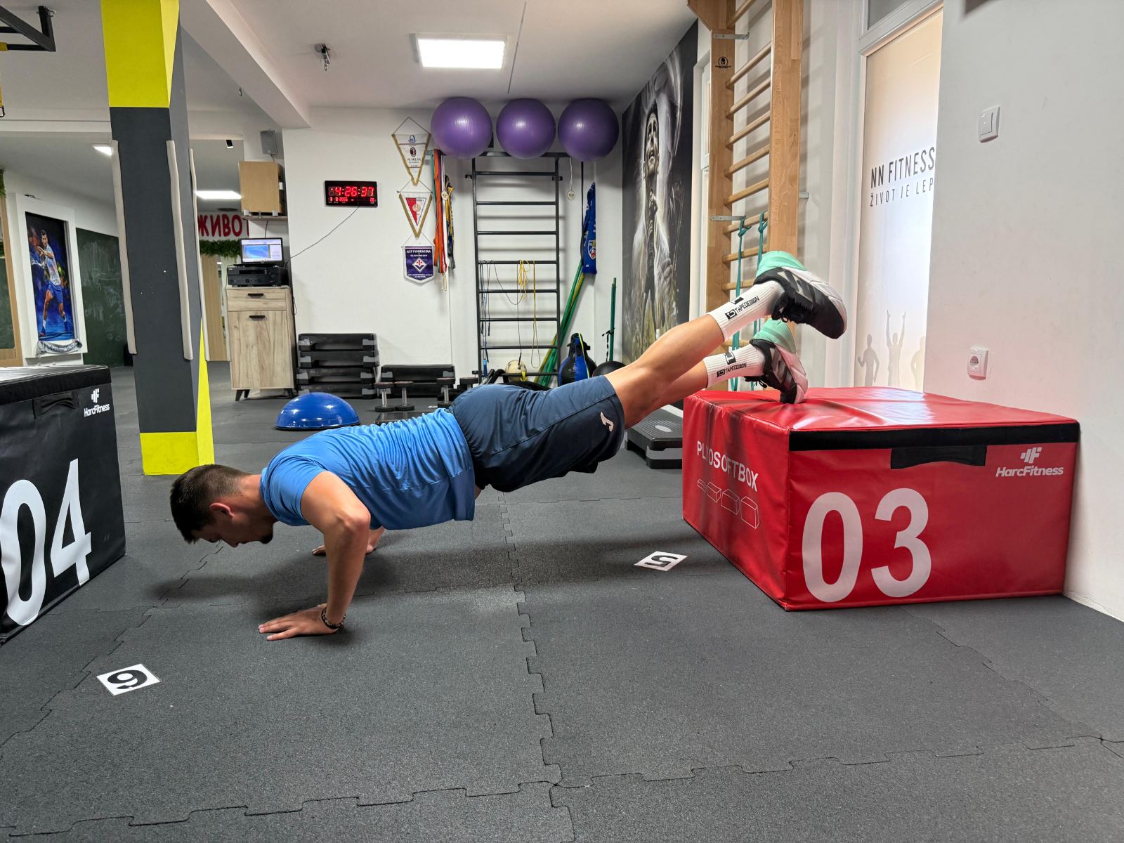 Sportista radi sklekove sa nogama na plyo sanduku