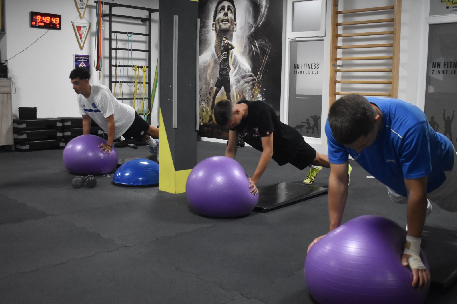 Mladi sportisti rade sklekove na fit lopti